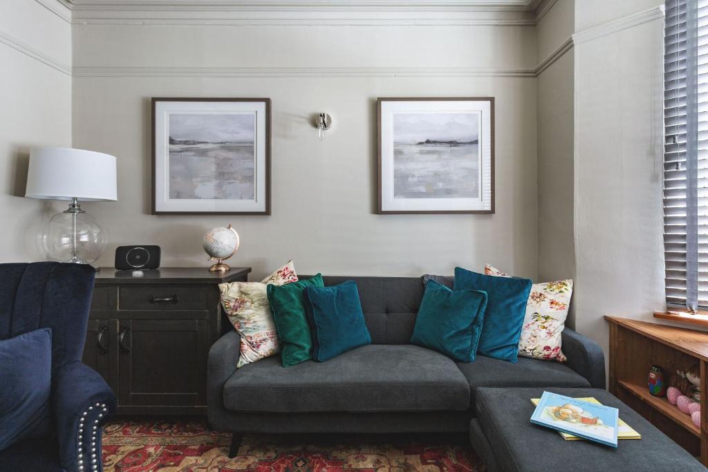 a living room with a gray couch and blue pillows at 44 Wellington Street in Matlock