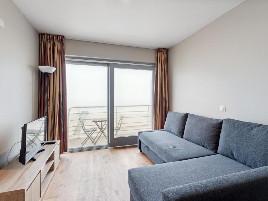 a living room with a couch and a tv at Ocean Suites on floor 10 in Blankenberge