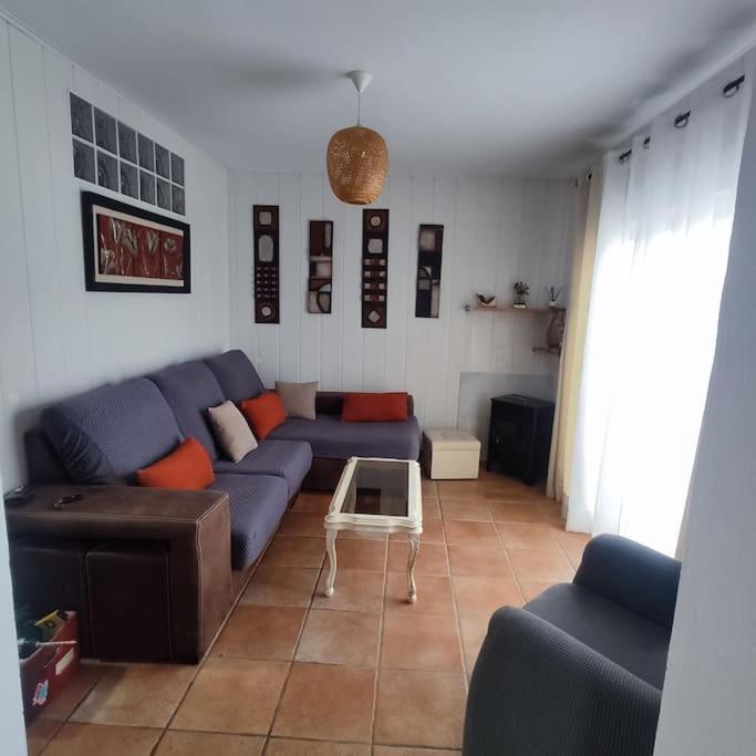 ein Wohnzimmer mit einem blauen Sofa und einem Tisch in der Unterkunft Vivienda cerca de Sotogrande in San Enrique de Guadiaro