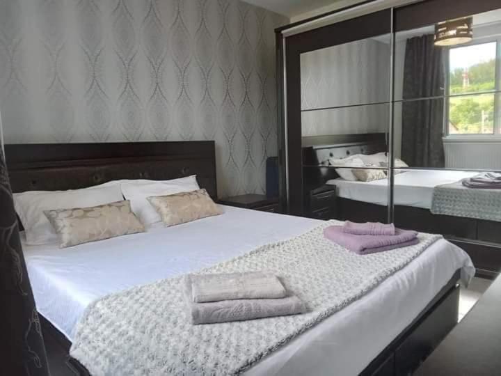 een slaapkamer met een bed met twee handdoeken erop bij NicoResident in Ocna-Mureşului