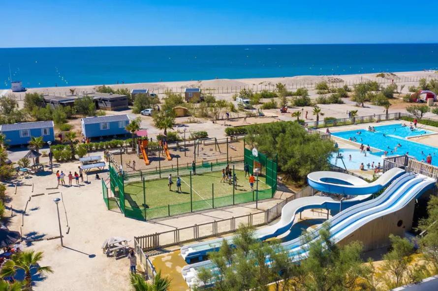 an amusement park with a playground and a pool at LES PIEDS DANS L'EAU A PALAVAS ! Mer à 50 m ! MHome 6 Pers climatisé T confort CAMPING 4 ETOILES in Palavas-les-Flots