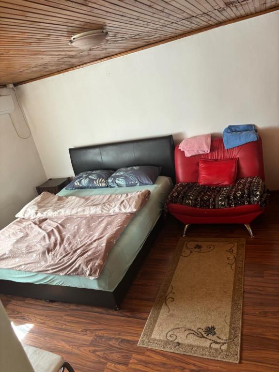 a bedroom with a bed and a couch and a chair at Miky Apartments in Podgorica