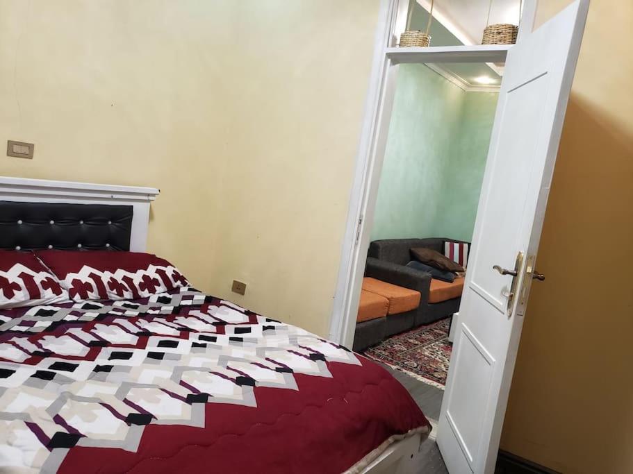sypialnia z czerwonym i białym łóżkiem oraz salon w obiekcie Guest House at the center of Addis Ababa. w Addis Abebie