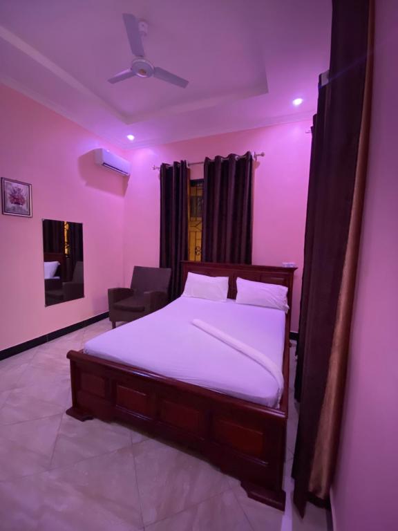 Schlafzimmer mit einem Bett mit lila Beleuchtung in der Unterkunft Sanic Lodge in Daressalam