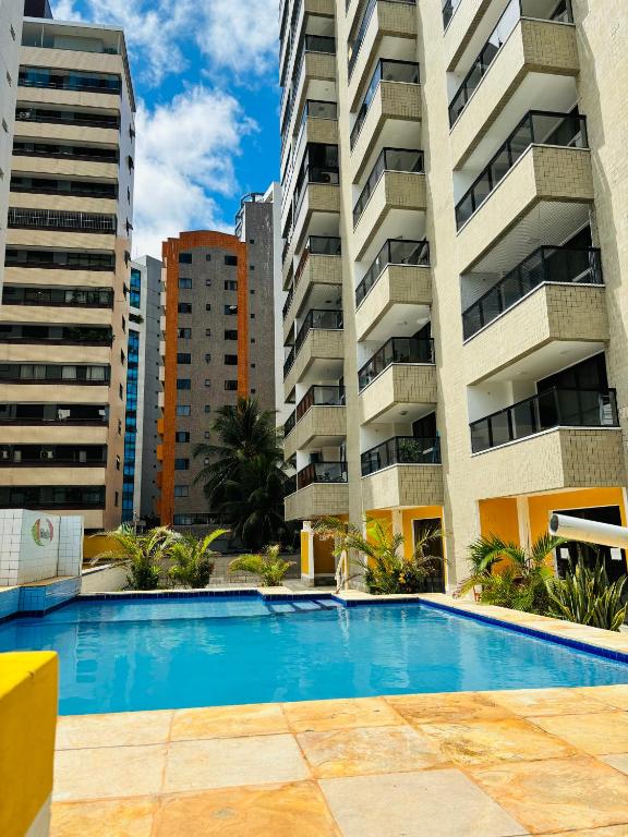 uma piscina em frente a dois edifícios altos em Via Venetto Flat em Fortaleza