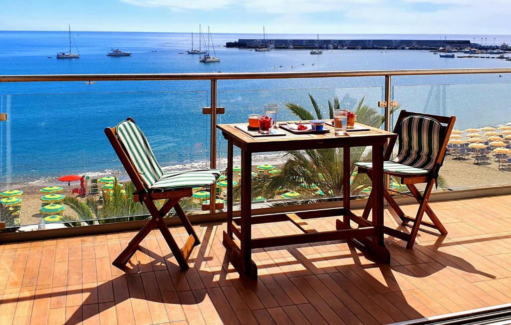d'une table et de deux chaises sur un balcon avec vue sur l'océan. dans l'établissement Awesome Apartment In Giardini Naxos With Wifi, à Giardini Naxos