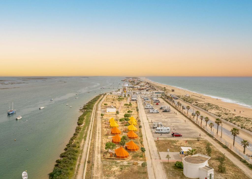 eine Luftansicht auf einen Strand mit Menschen und das Meer in der Unterkunft Glamping Camp Faro in Faro