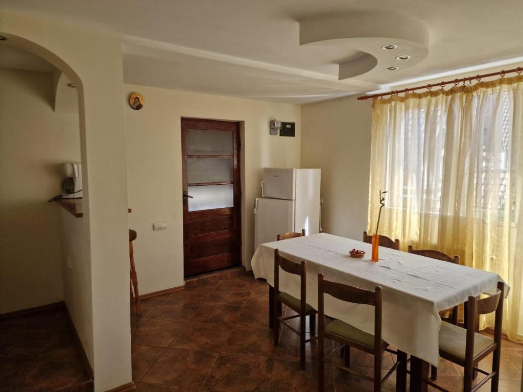 een keuken met een tafel en stoelen en een koelkast bij Casa Maria Busteni - Poiana Tapului in Buşteni