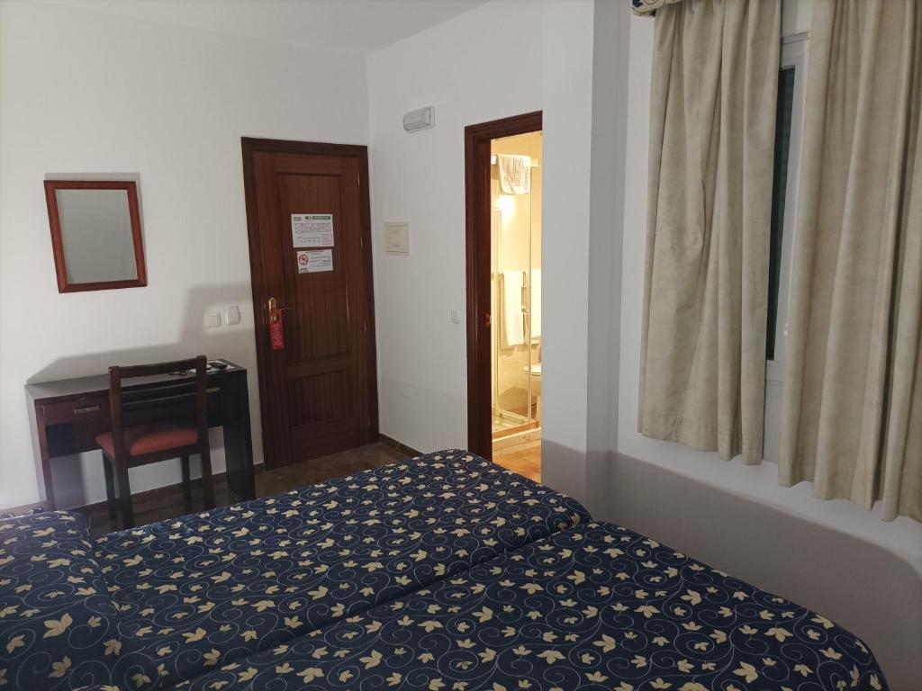 Postel nebo postele na pokoji v ubytování Hostal San Cayetano