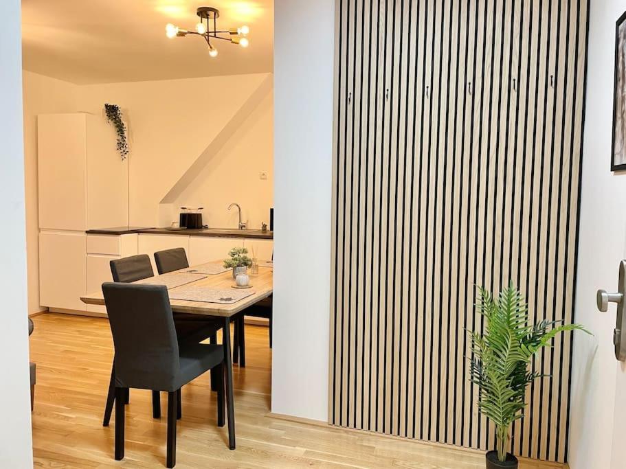 ein Esszimmer mit einem Tisch und einer Küche in der Unterkunft Modern Rooftop Apartment with Free Parking in Wien
