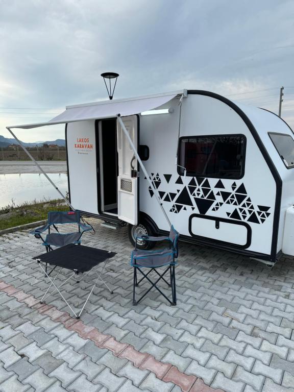 a white trailer with two chairs and a table at KÜKÜRT TESİSİ in Dalaman