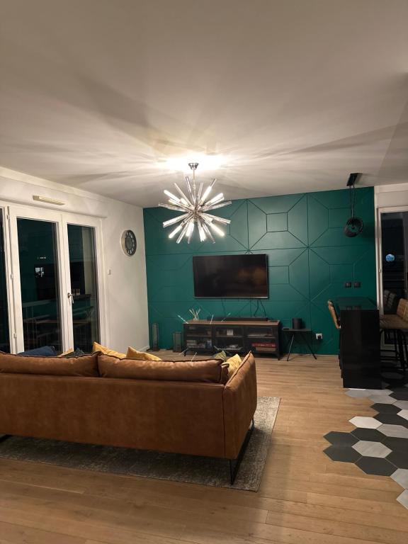 un salon avec un canapé et une télévision à écran plat dans l'établissement Très bel appartement de 4 pièces, à Saint-Ouen