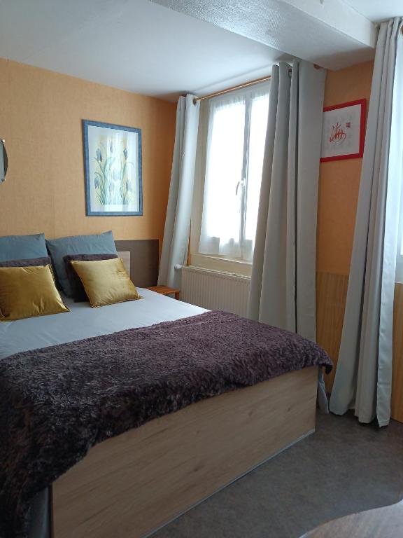 - une chambre avec un grand lit et une fenêtre dans l'établissement Chambre dans le centre historique, à Pont-Audemer
