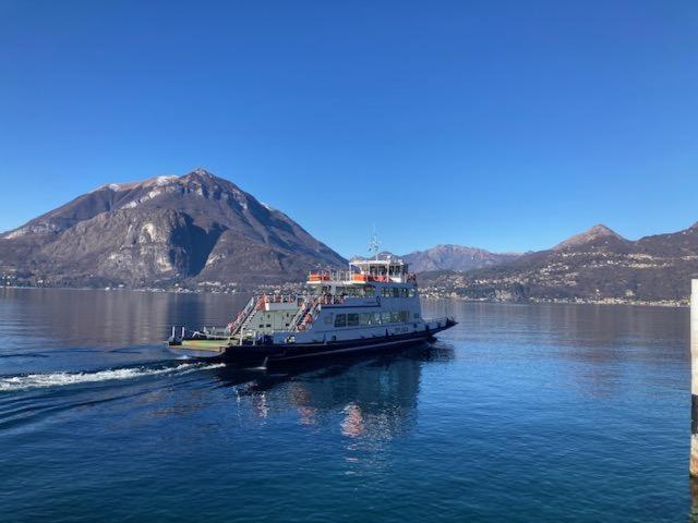 a boat on the water with a mountain in the background at Emma House in Bellano