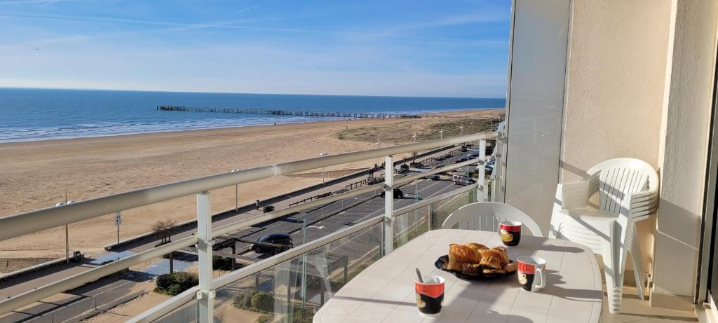 une table sur un balcon avec vue sur la plage dans l'établissement Le Lido, à Saint-Jean-de-Monts