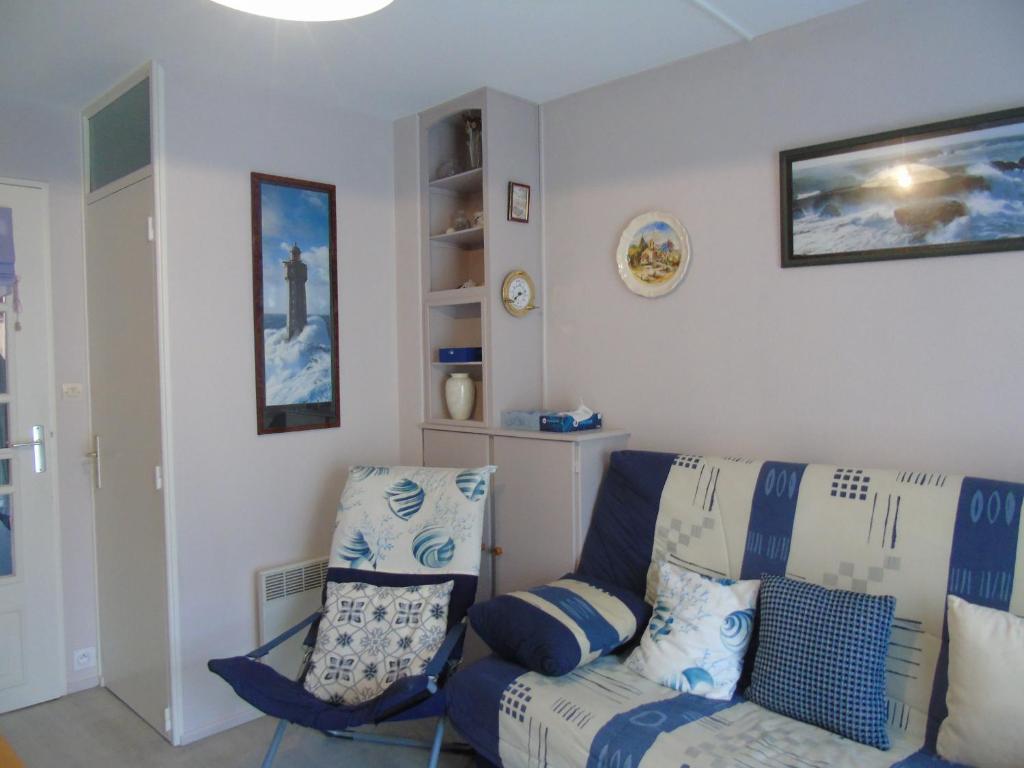 ein Wohnzimmer mit einem Sofa und einem Stuhl in der Unterkunft Maison a 2 pas de la plage in Plage-des-Demoiselles