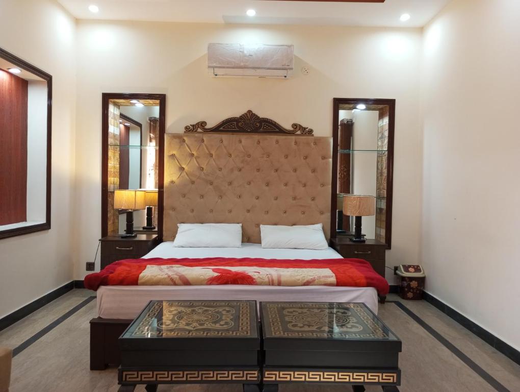 a bedroom with a large bed and two mirrors at Khayaban-e-Amin Luxurious Apartments in Lahore