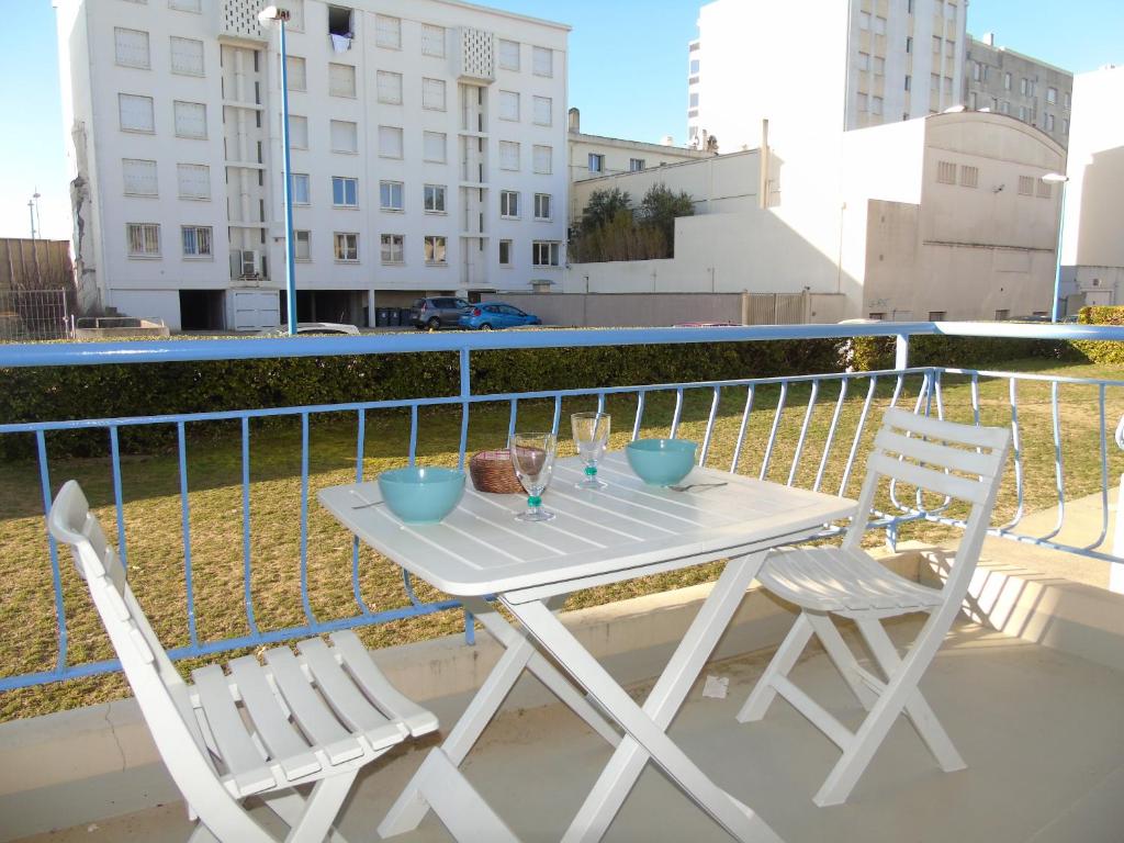 d'une table blanche et de deux chaises sur un balcon. dans l'établissement Les Vignes, à Saint-Jean-de-Monts
