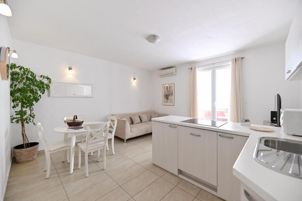 een keuken en een woonkamer met een tafel en een bank bij Near old town apartment with free parking and air condition in each room in Zadar