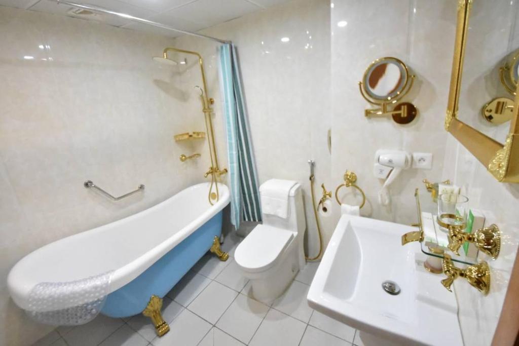 La salle de bains est pourvue d'une baignoire, de toilettes et d'un lavabo. dans l'établissement Adamaoua Grand Hôtel Aéroport, à Douala