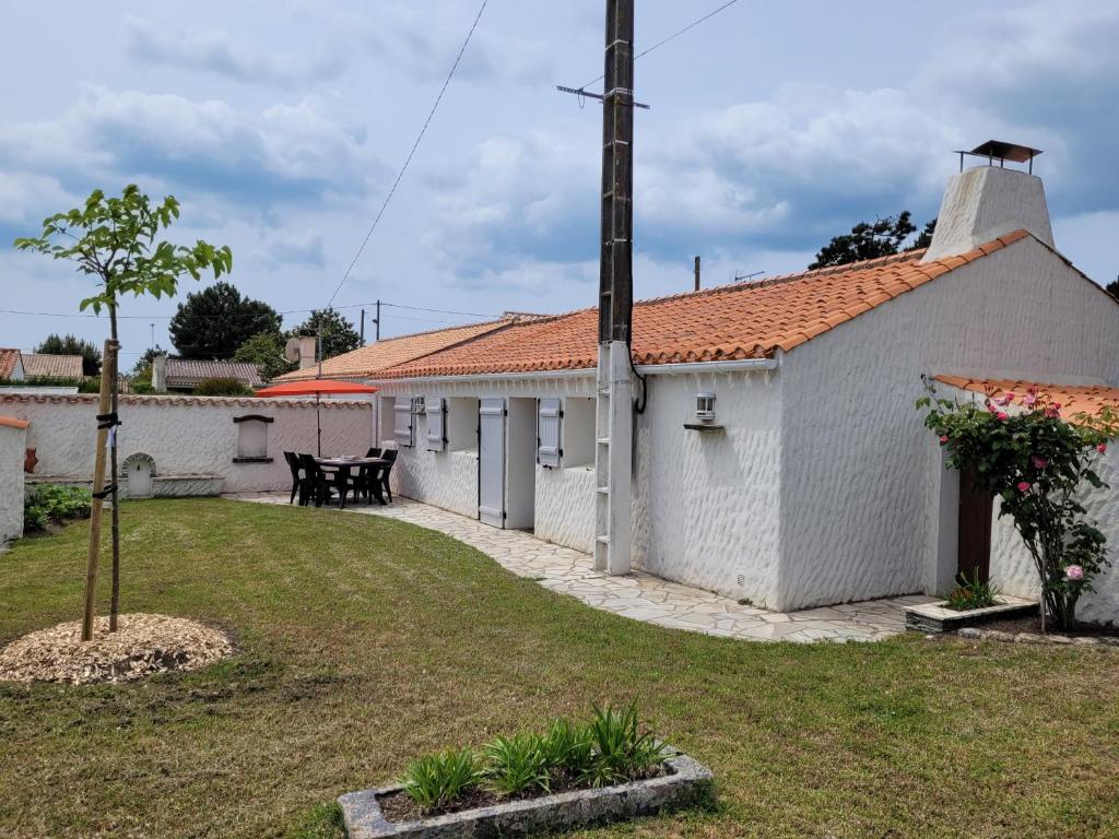 - une vue sur l'extérieur d'une église blanche avec une cour d'herbe dans l'établissement Charmante maison de vacances, à Saint-Jean-de-Monts