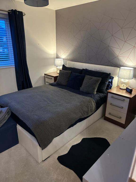 1 dormitorio con 1 cama grande y 2 mesitas de noche en Cosy double bedroom with dedicated bathroom in Newcastle upon Tyne - Access to shared kitchen, shared lounge and shared conservatory areas inc Sky TV and Netflix, en Newcastle