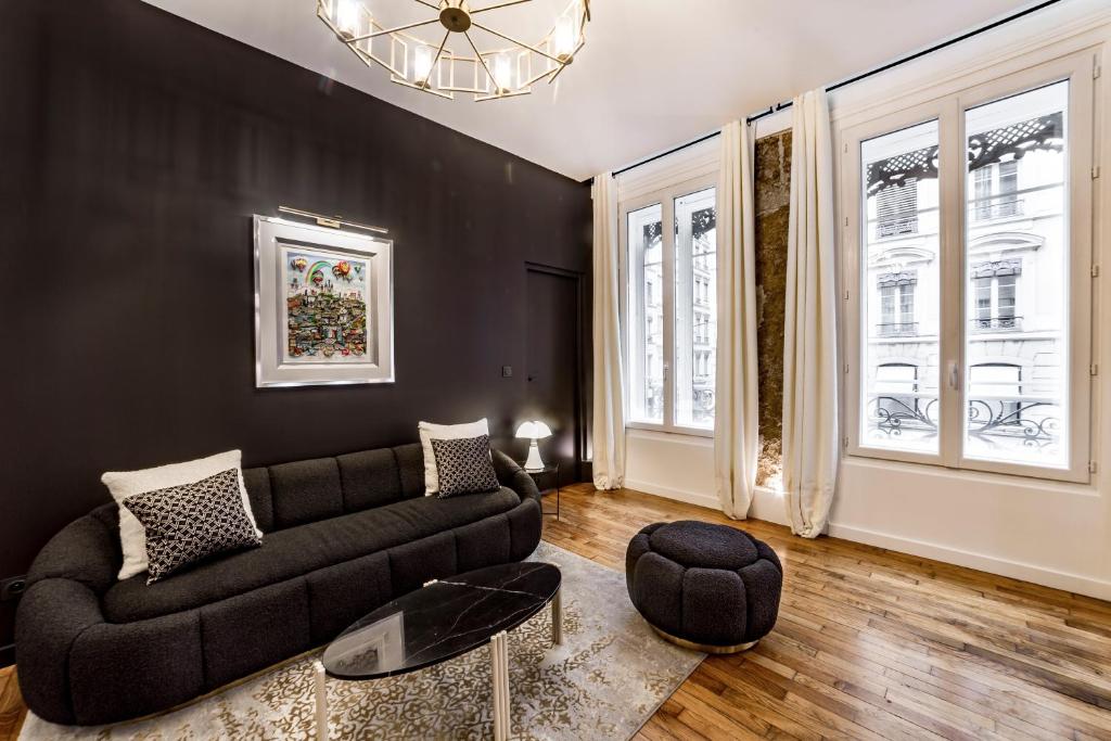 un salon avec un canapé et quelques fenêtres dans l'établissement Les Jacobins, hypercentre, à Lyon