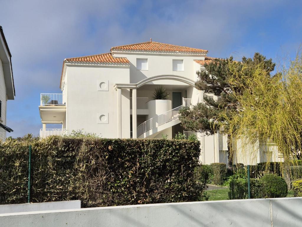 une maison blanche avec un toit en carrelage dans l'établissement L'Hollywood, à Saint-Jean-de-Monts