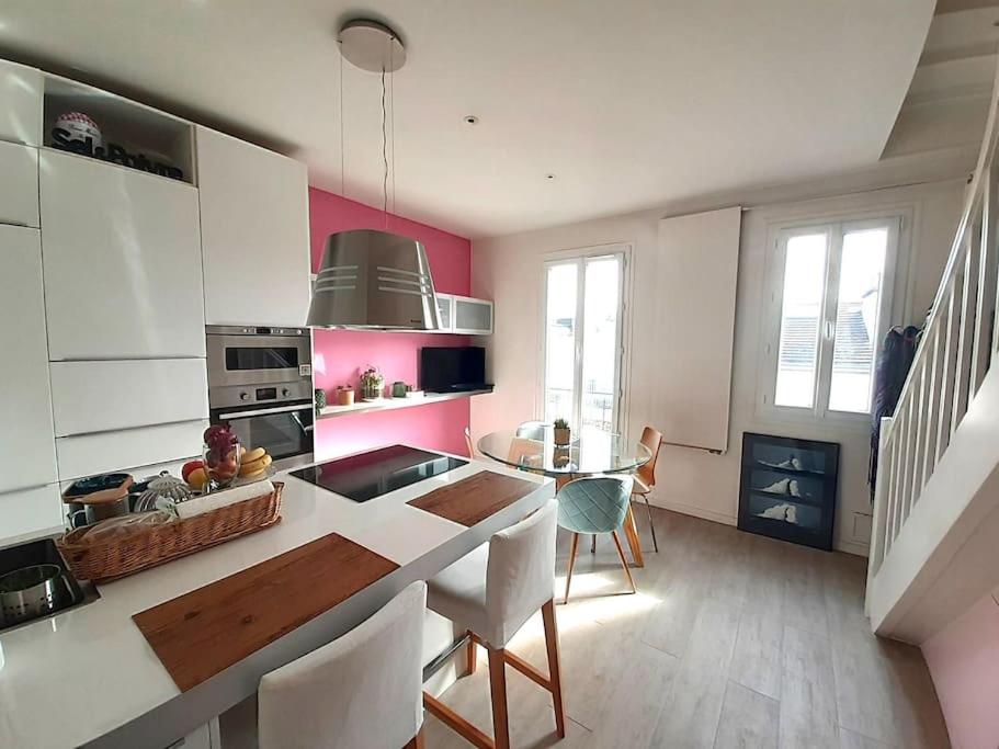 uma cozinha com paredes cor-de-rosa e brancas e uma mesa em Le DUPLEX de Boulogne/Roland Garros/1 à 4 personnes em Boulogne-Billancourt