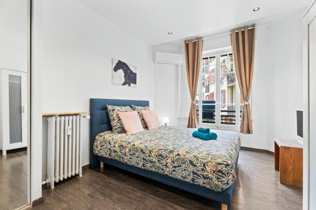 1 dormitorio con cama azul y almohadas rosas en Nice Renting - PAGANINI - New Lovely Cosy Flat in Heart of Nice, en Niza