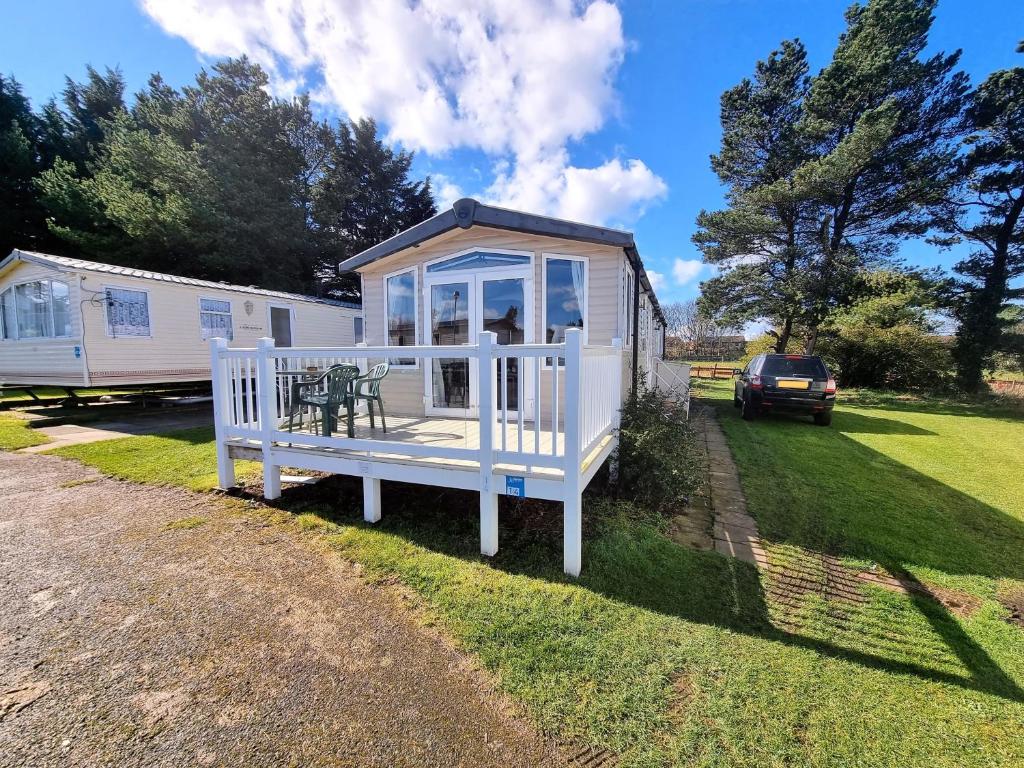 a tiny house with a porch and a table at Stunning modern lodge in Port Seton