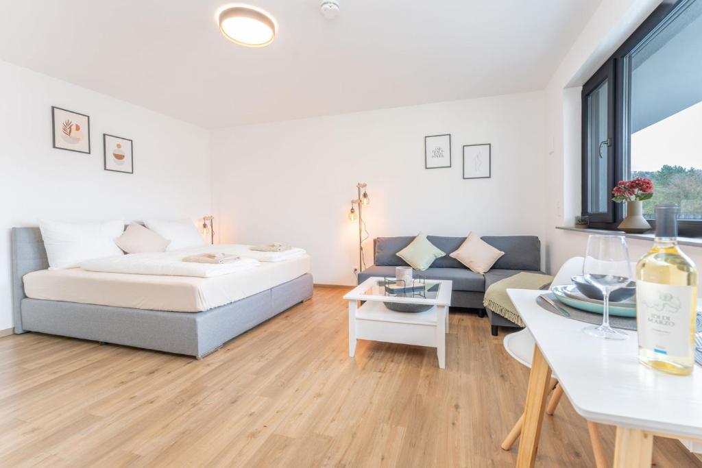 ein Wohnzimmer mit einem Bett und einem Sofa in der Unterkunft Modernes Apartment mit privatem Stellplatz wenige Minuten von der Innenstadt & Mosel in Koblenz