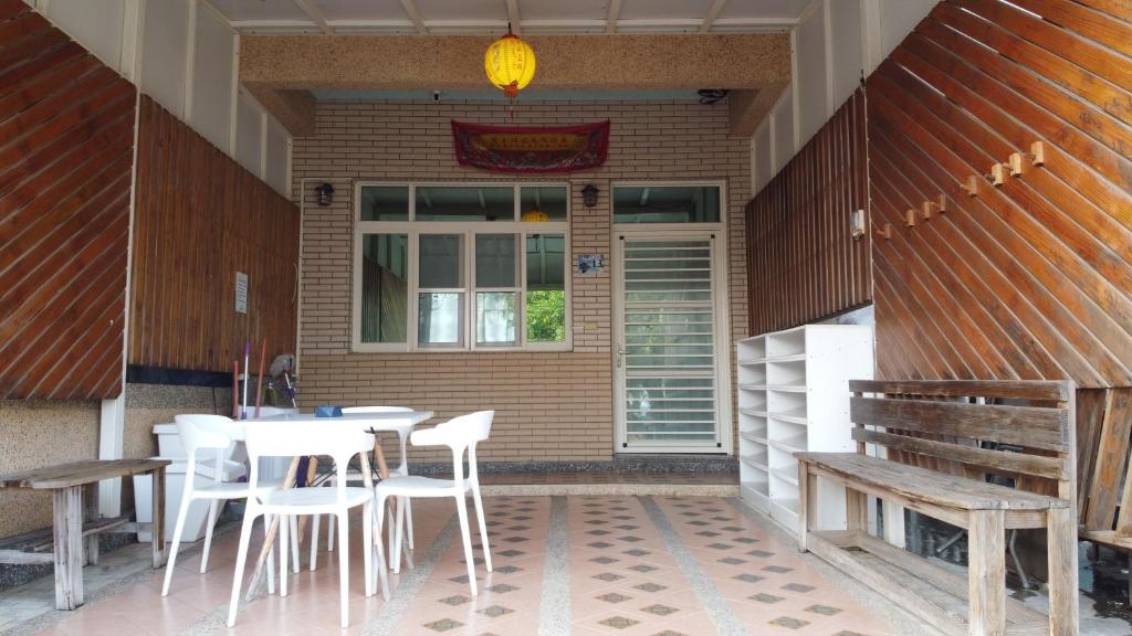 eine Terrasse mit einem Tisch, Stühlen und einem Fenster in der Unterkunft Loju sunrise inn in Xiaoliuqiu