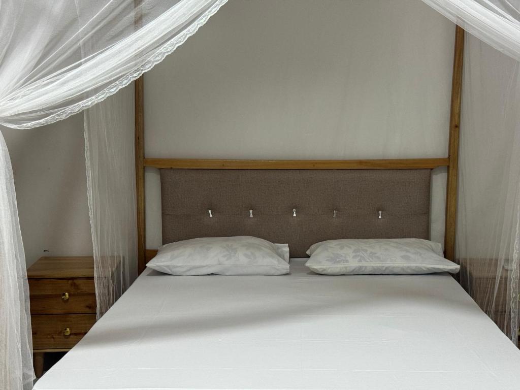 een bed met twee kussens in een slaapkamer bij Winnie's Home in Morogoro