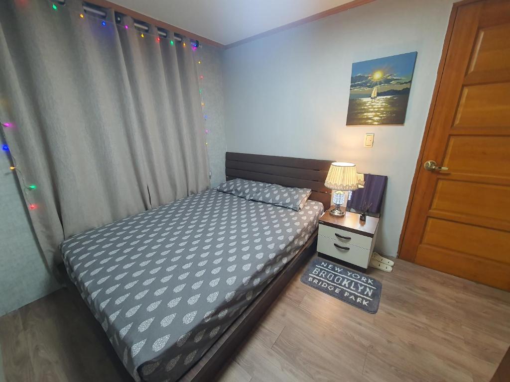 ein kleines Schlafzimmer mit einem Bett und einer Tür in der Unterkunft Seoul room ONLY GIRLS in Seoul