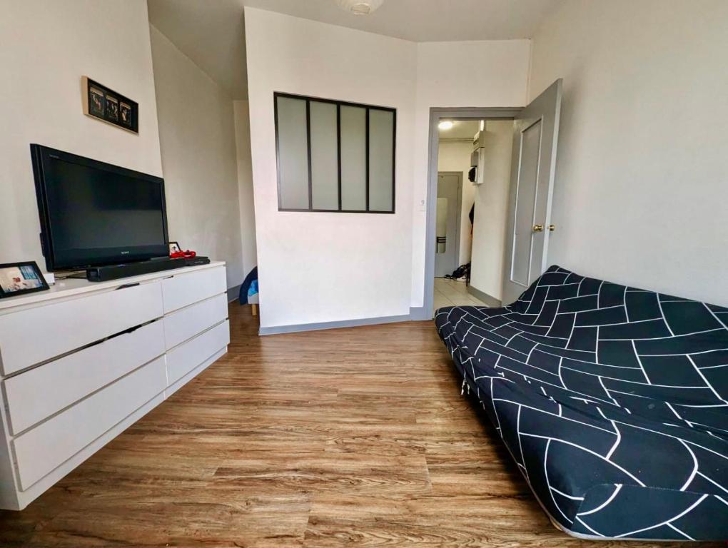 une chambre avec un lit et une télévision à écran plat dans l'établissement Excellent T2 - 5min Gare & HyperCentre, à Grenoble