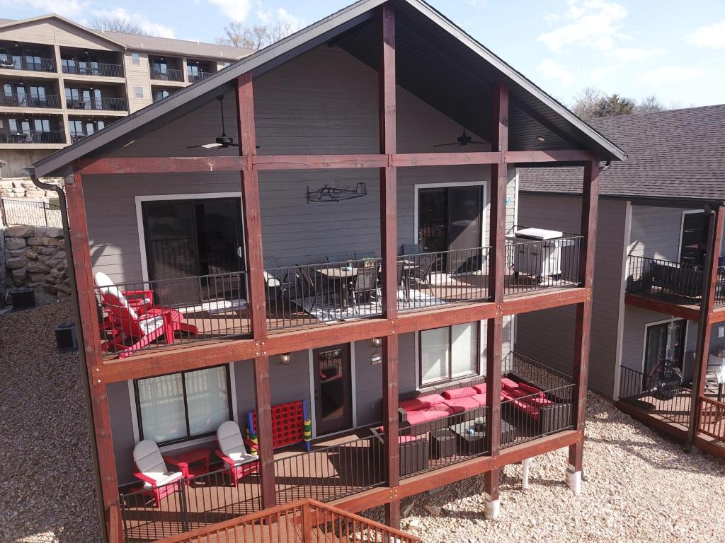 a house with a deck with red chairs on it at Luxury Lake Resort Lodge in Branson