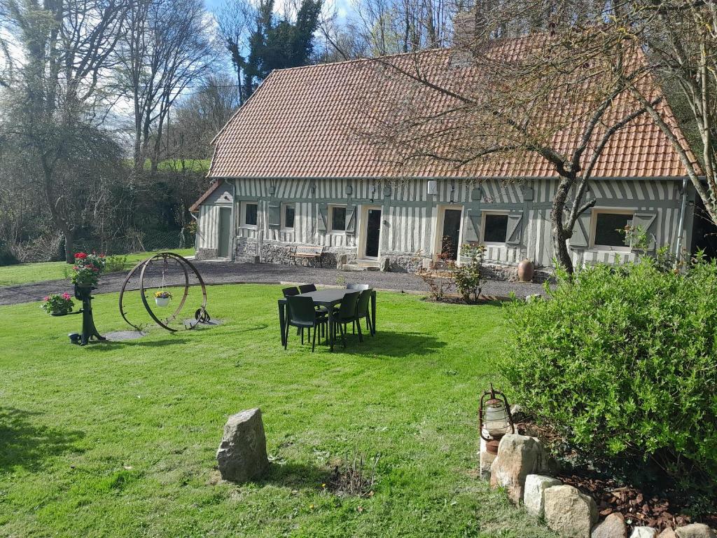 a house with a table and a playground in the yard at Maison de 3 chambres avec jardin clos et wifi a Offranville a 4 km de la plage in Offranville