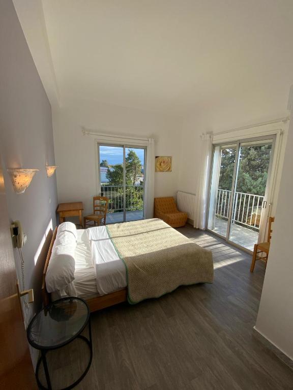 a bedroom with a large bed and a balcony at HOTEL LE FLOREAL in Le Soler