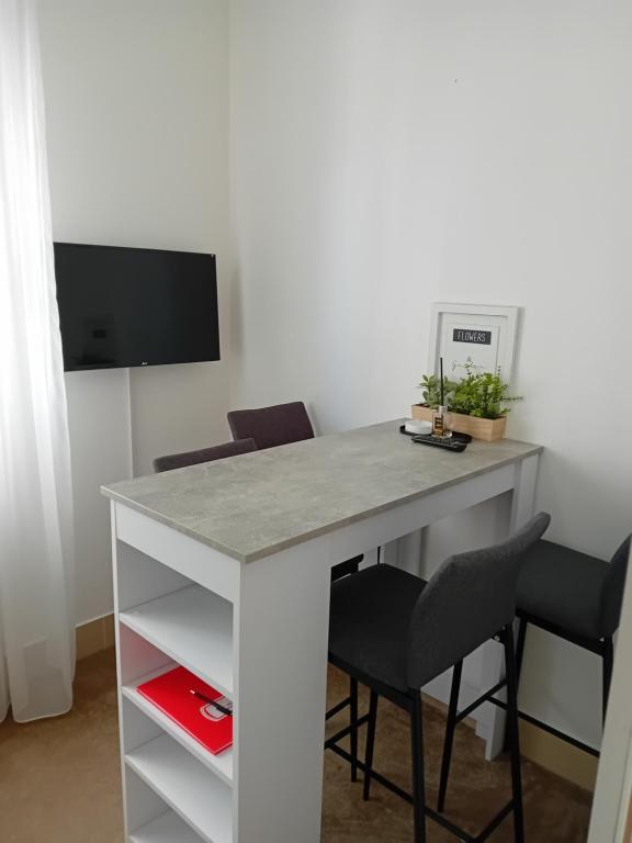 a white desk with two chairs and a television at Wing Nina2 in Jagodina