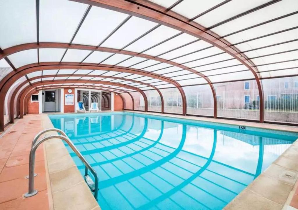 une grande piscine avec un grand plafond dans l'établissement Le Nid Canal Piscine Résidence, à Béziers