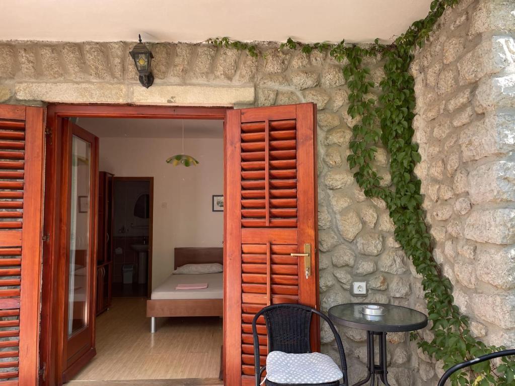 a room with a table and a door and a table and chairs at Apartmani Jović 2 in Mali Lošinj