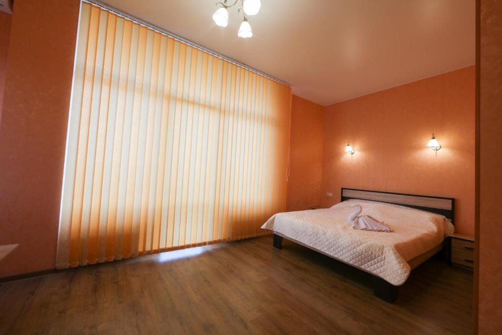 a bedroom with a bed and a large window at Guest House Voyazh ГОСТЕВОЙ ДОМ "ВОЯЖ" in Livadiya
