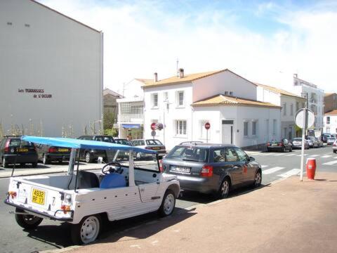 un carrito de golf blanco estacionado al lado de una calle en Grande maison 40m de la plage de Pontaillac, en Royan