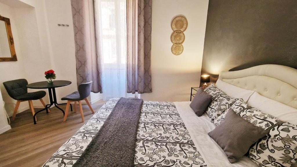 ローマにあるMyomax Guesthouseのベッドルーム1室(ベッド1台、テーブル、椅子付)