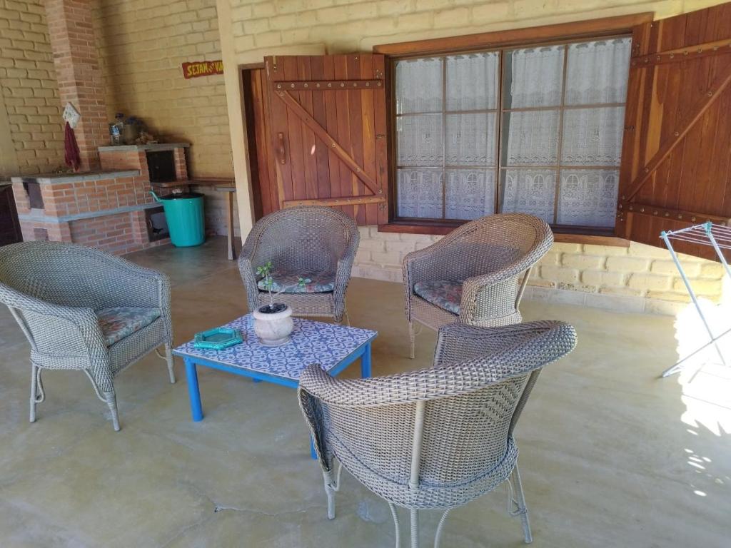 a room with chairs and a table and a window at Chalés Pássaros do Cerrado in Cavalcante