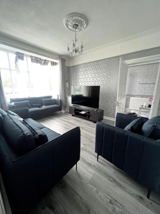 Hotel No. 206 - Spacious 5 Bed, a living room with blue couches and a television at No. 206 - Spacious 5 Bed in Liverpool