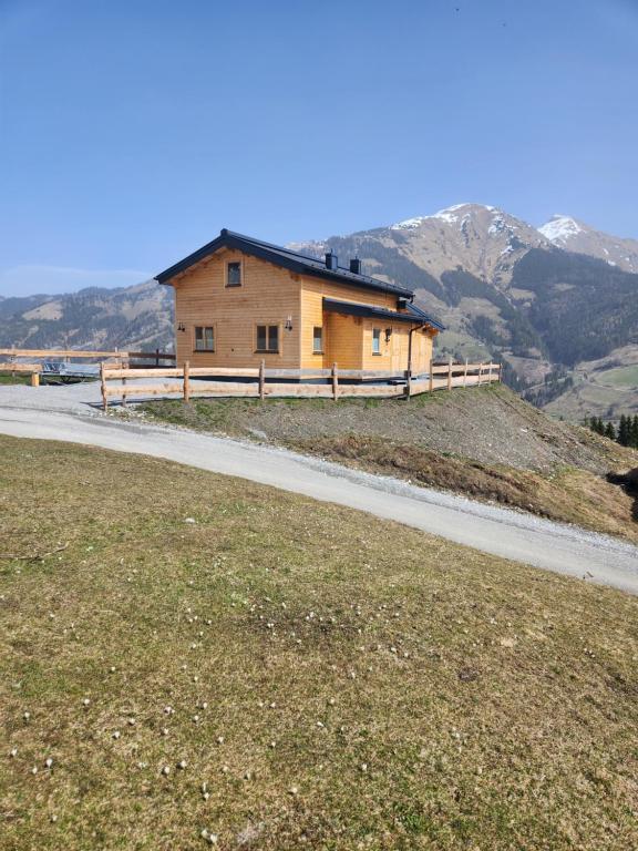 a house on a hill next to a road at Lipphütte Top Lage mit traumhafter Aussicht in Rauris