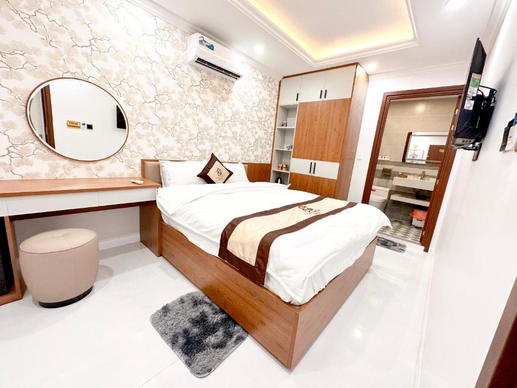 um pequeno quarto com uma cama e um espelho em Chuly Moon Motel em Hà Tiên