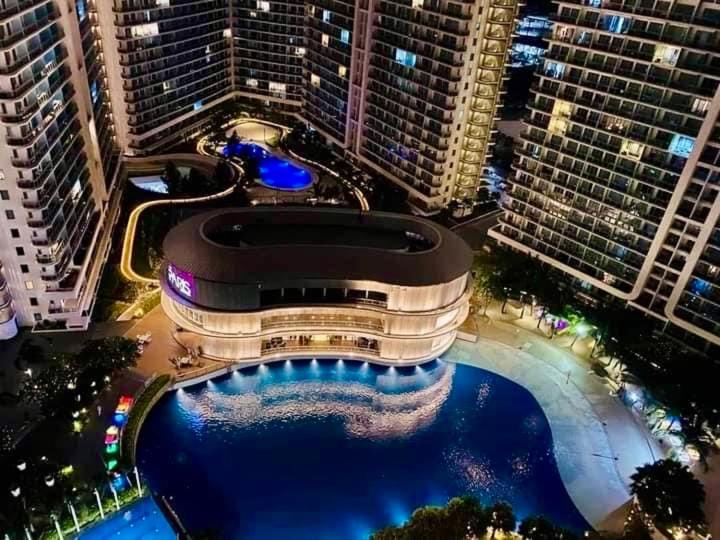 un gran edificio con piscina frente a edificios altos en Bellescapes - Azure Resort (1 BR with Balcony), en Manila